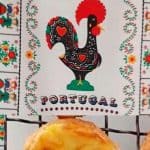 1 Portugese Belém Tart (Milky filling on a crust)) on a patterned cloth with a rooster image from Portugal