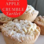 small single serving apple crumble tarts with a dusting of icing sugar