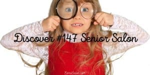 Small girl with long hair with magnifying glasses in front of her eyes