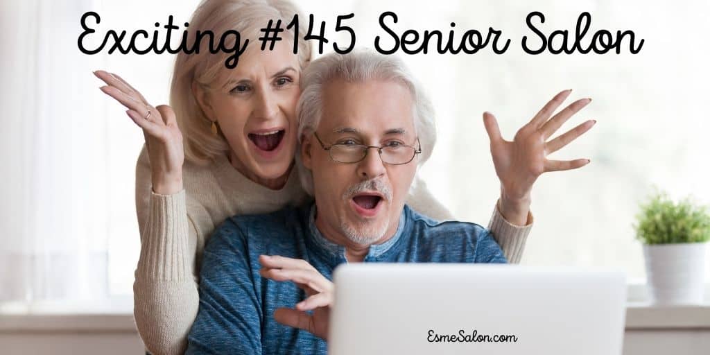 two seniors looking at computer screen and lady very happy with hands in the air
