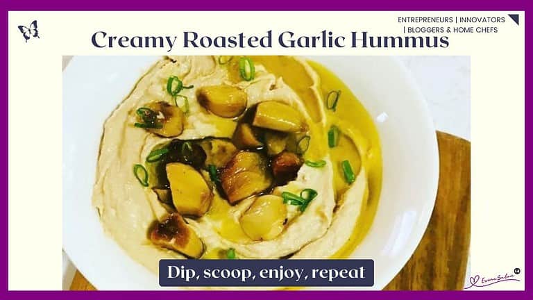 an image of a white bowl filled with Creamy Garlic Roasted Hummus on wooden table with some crisps as well