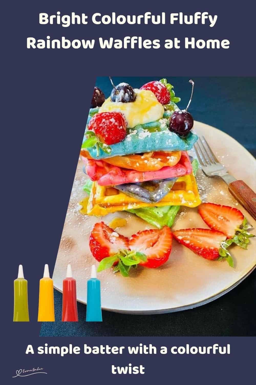 An image of a stack of colourful, fluffy, rainbow waffles with fruit and some cherries