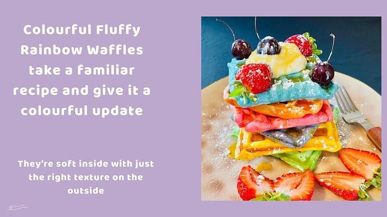An image of a stack of colourful, fluffy, rainbow waffles with fruit and some cherries