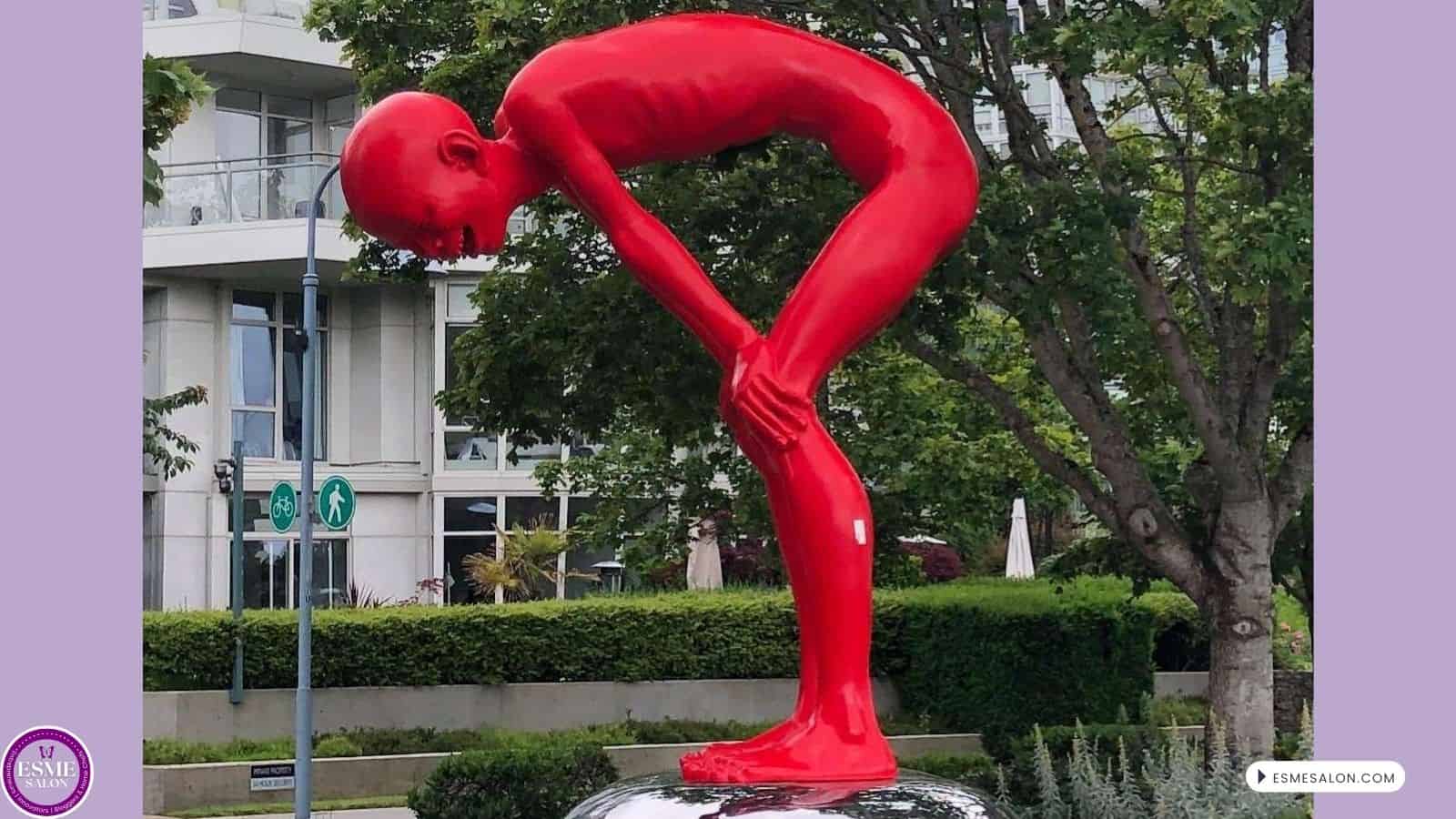 an image of a red statue: The cheeky expression and arresting pose are a celebratory call to the audiences, inviting them to embrace their inner child.