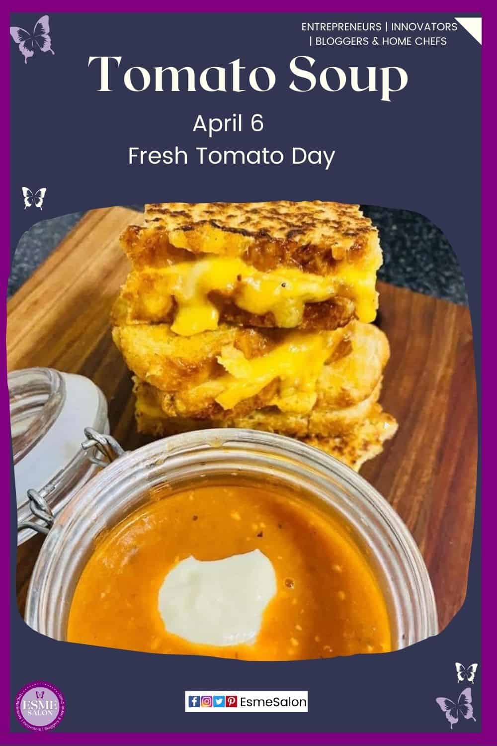 an image of a bowl of fresh tomato soup with a dollop of cream and toasted cheese sandwiches on the side