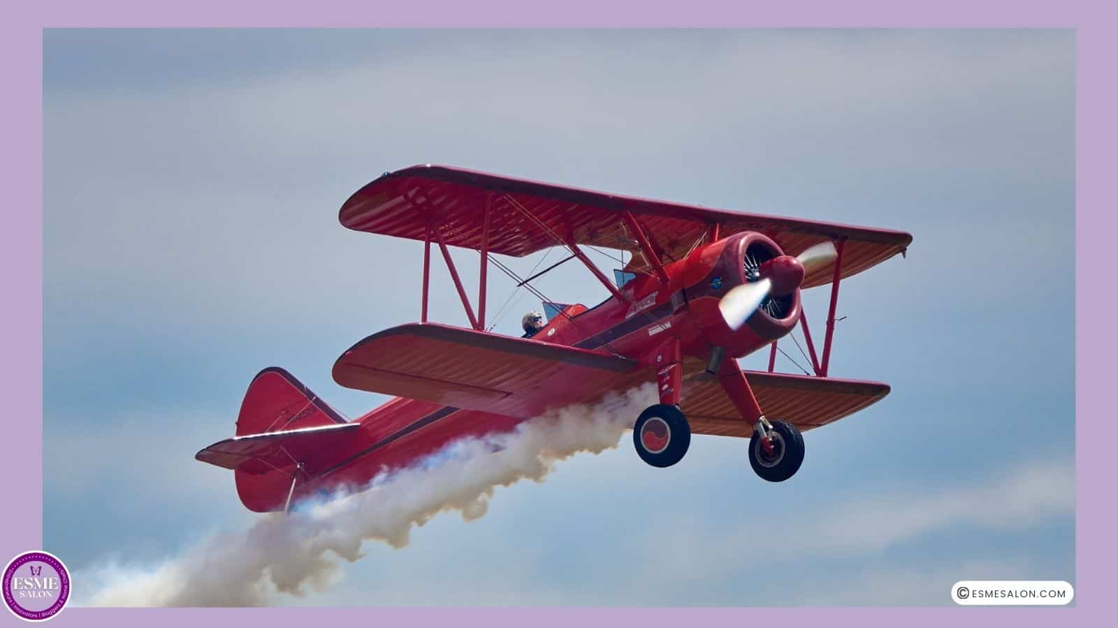 an image of a red biplane in flight