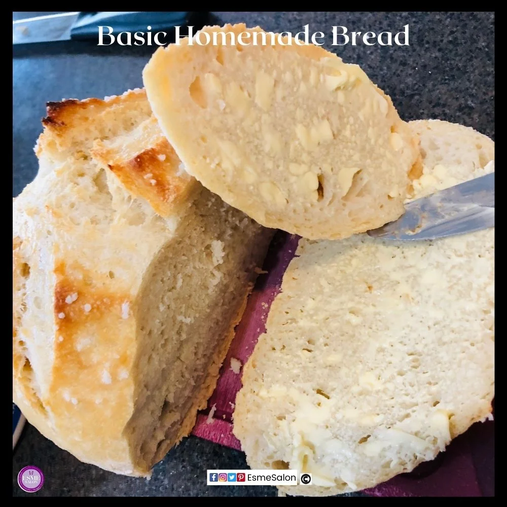 an image of a 4 ingredient round artisan bread sliced and buttered on a red cutting board