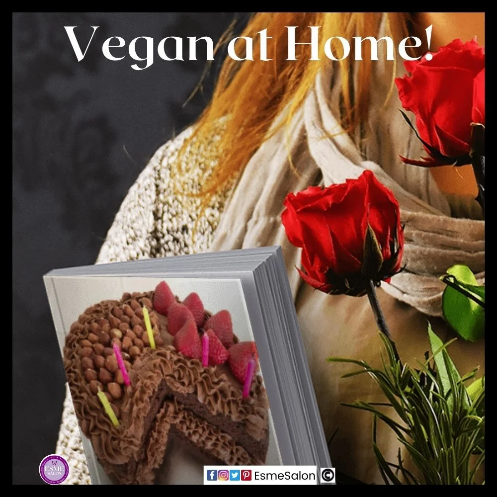 an image of a lady holding two red roses as well as a book with a vegan birthday chocolate cake on the cover decorated with strawberries and nuts as well as 5 candles