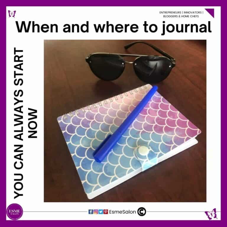 an image of a colorful notebook with a blue ben and a pair of black sunglasses on a brown desk