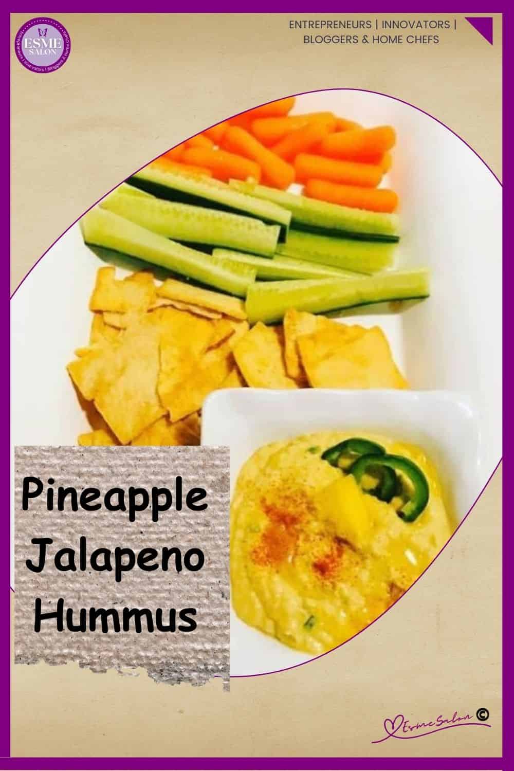 an image of a white plate with cucumber sticks, carrots and crackers as well as a bowl of Pineapple Jalapeno Hummus drizzles with oil and decorated with peppers
