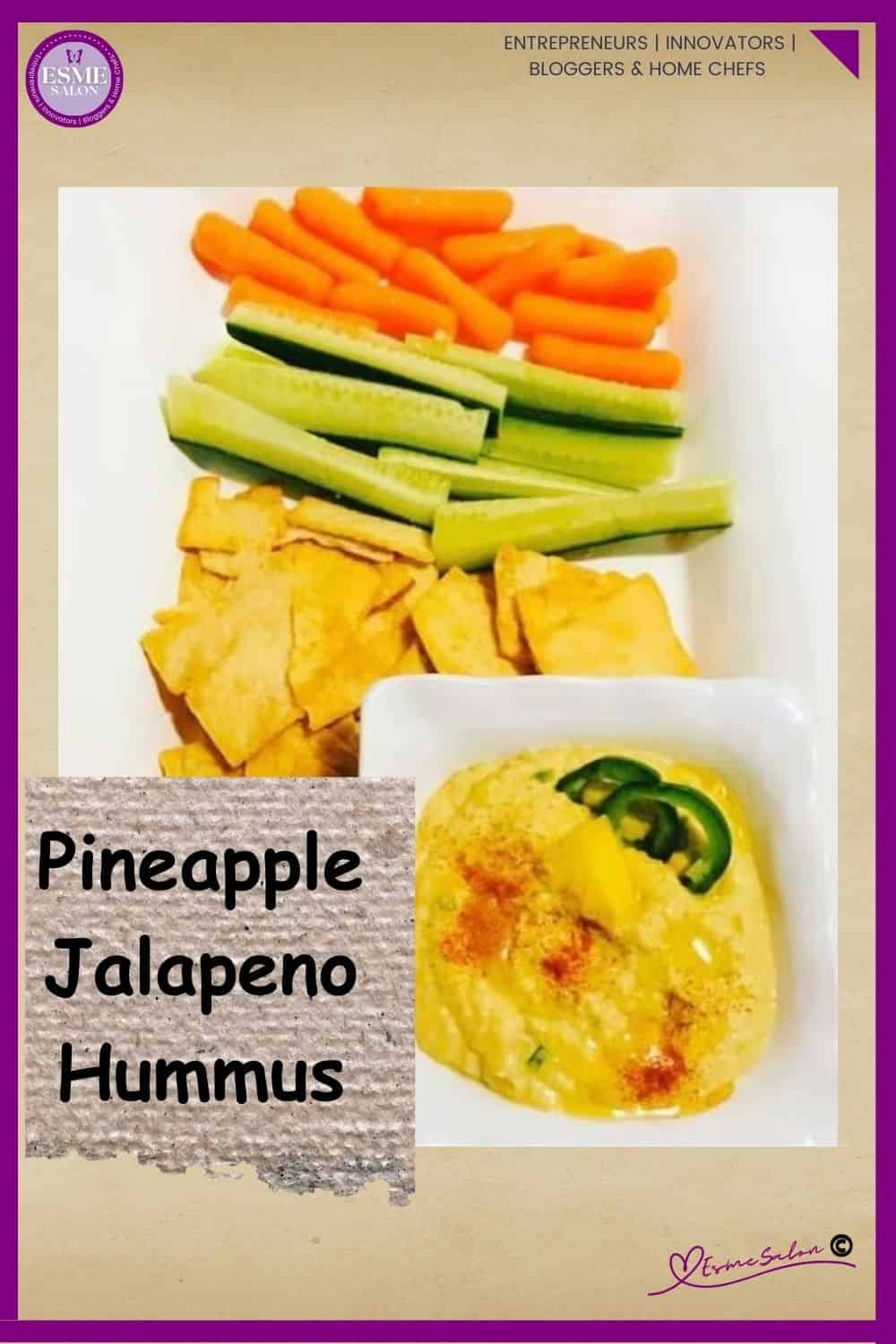 an image of a white plate with cucumber sticks, carrots and crackers as well as a bowl of Pineapple Jalapeno Hummus drizzles with oil and decorated with peppers