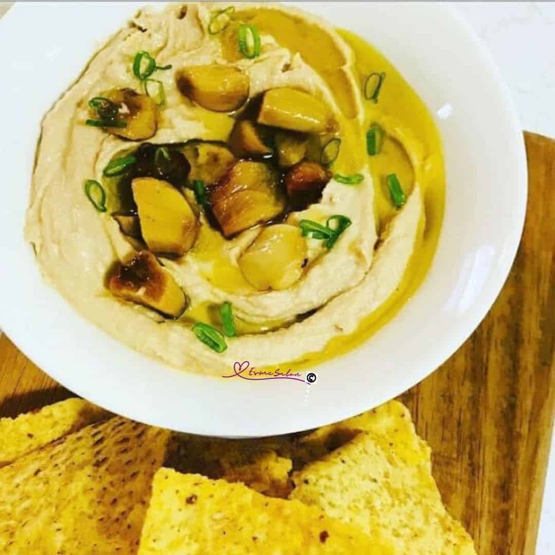 an image of a white bowl with Creamy Roasted Garlic Hummus