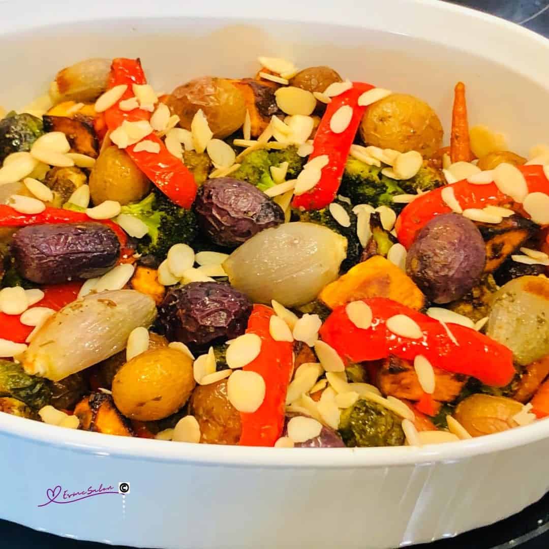 an image of a white Pyrex dish filled with Roasted Veggie Extravaganza and slivered almonds 