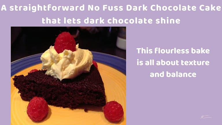 An image of a No Fuss Dark Chocolate Cake with a small dollop of cream and a few raspberries