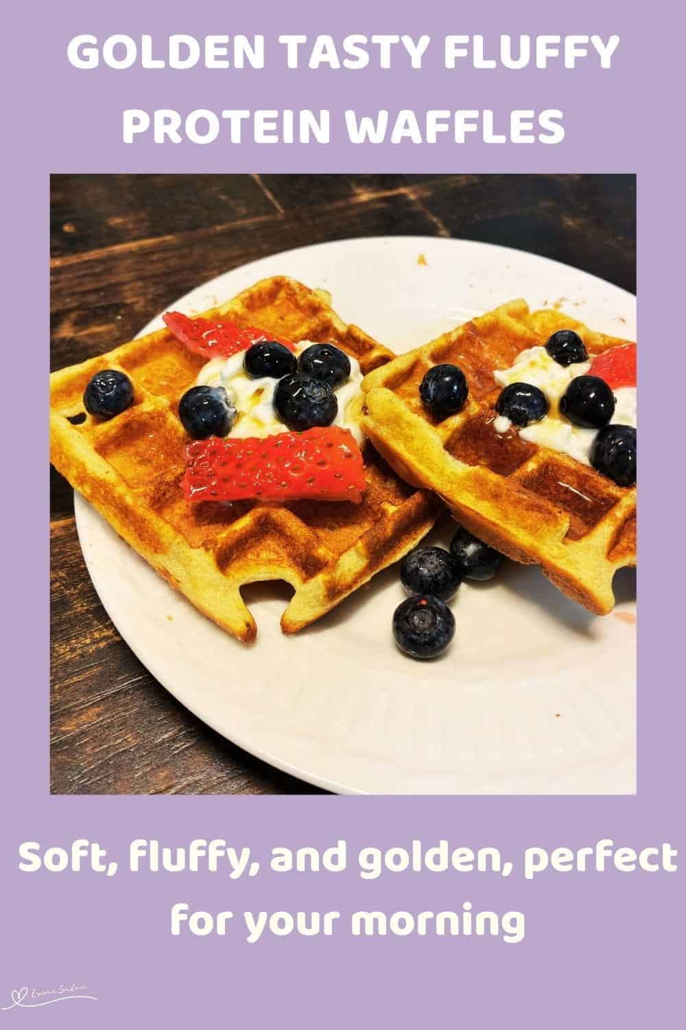 An image of Fluffy Protein Waffles with a dollop of cream, blue berries and strawberries