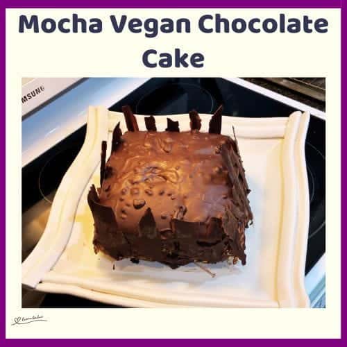 An image of a 3-layer Mocha Vegan Chocolate Cake with ganache and chocolate shards