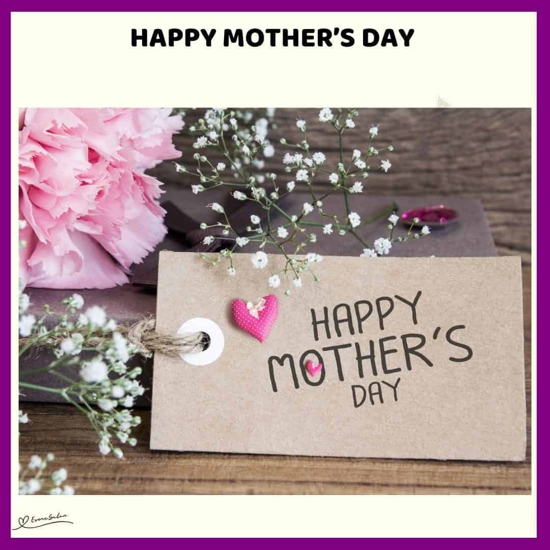 An imagfe of pink carnations with baby's breath and a card with Happy Mother’s Day written on it
