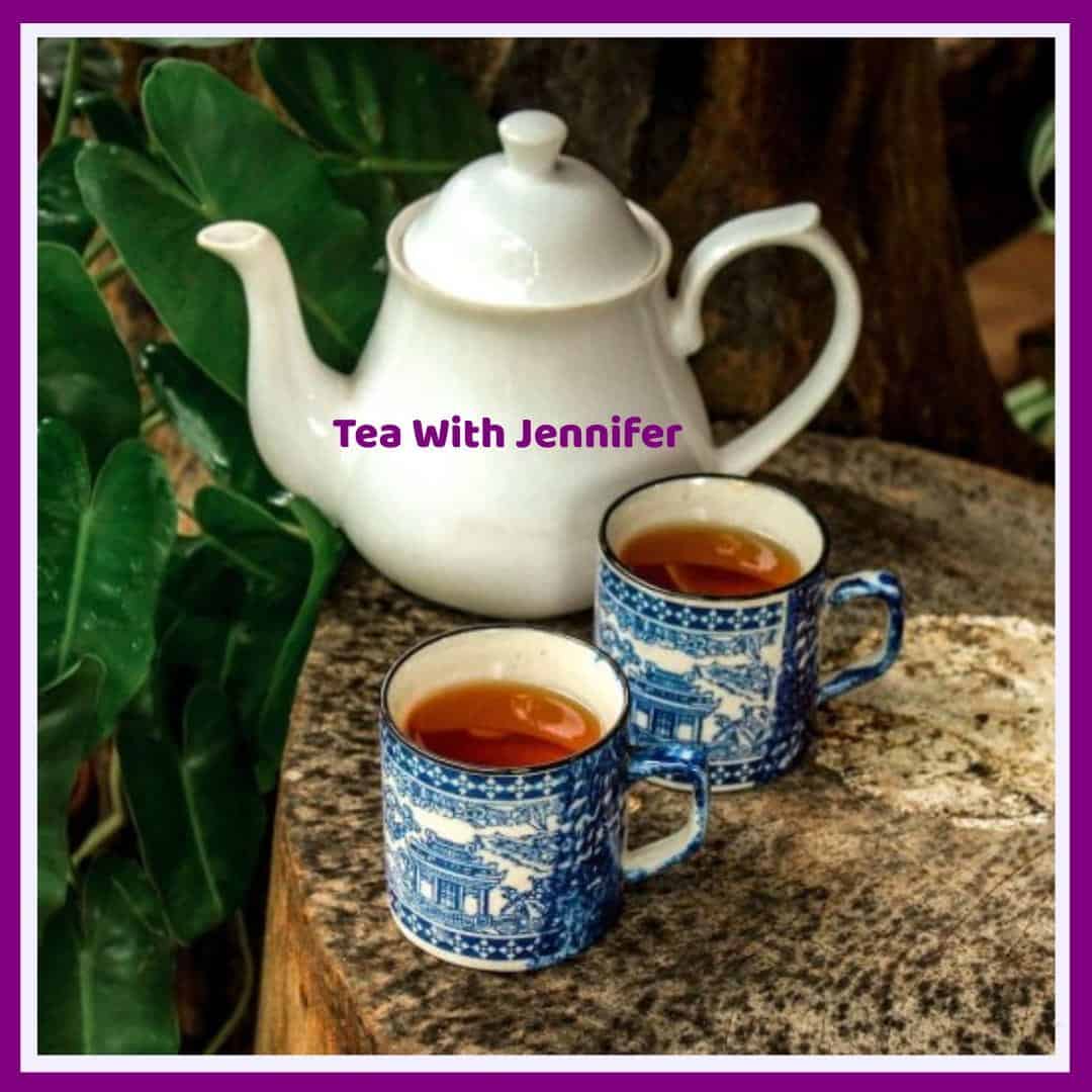 An image of a white teapot and two mugs of tea