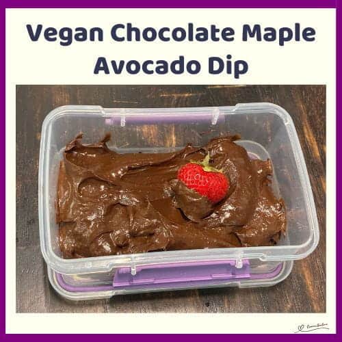 An image of a Vegan Chocolate Maple Avocado Dip in a plastic container with a dipped strawberry