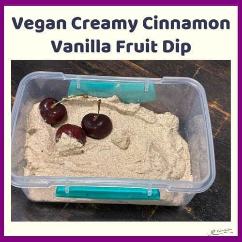 An image of a small plastic container filled with Vegan Creamy Cinnamon Vanilla Fruit Dip with 3 cherries in the one corner